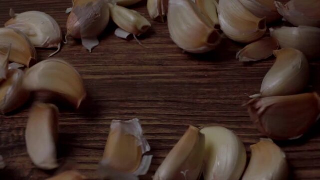 Falling Garlic Cloves on Wooden Surface