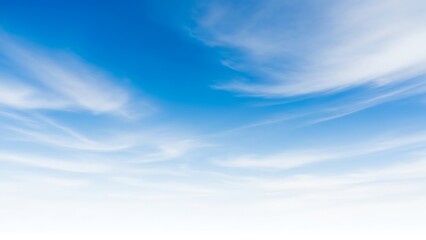 Fototapeta premium Beautiful, wide-angle view of a clear blue sky with wispy white clouds creating a sense of vastness and tranquility