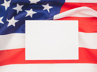 Blank white paper on star striped flag background with copy space.