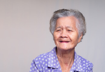Elderly woman with toothless smile and natural expression.