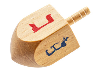 Wooden dreidel with painted Hebrew letters, ready to spin