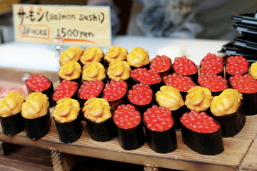 Many pieces of sushi made from salmon and unagi on the wooden tray for selling