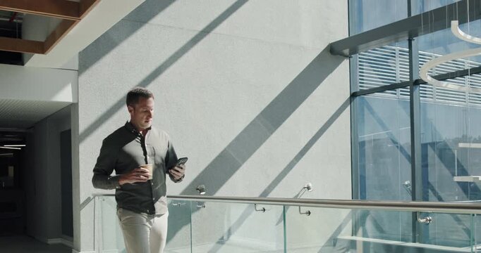 Businessman, walking and network with phone for morning schedule, conversation or chat in workplace. Man, employee or checking messages with mobile smartphone for work agenda, tasks or connectivity