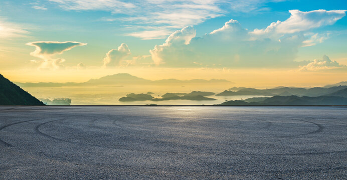 Empty asphalt race track road and sea with mountain island landscape at beautiful sunrise