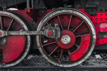Fototapeta premium A detailed view of a red steam locomotive wheel set, showing weathered metal
