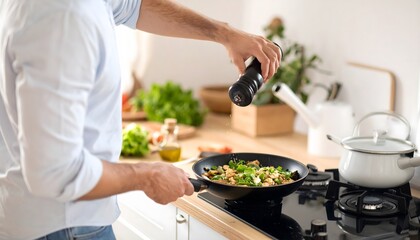 Man Seasoning Savory Stir Fry in Modern Kitchen