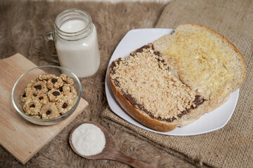 Naklejka premium Bread with peanut, chocolate and butter spread on a table for breakfast 