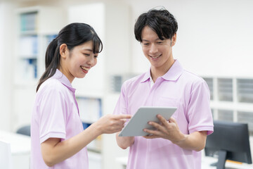 介護施設の事務所の若い男女の介護士