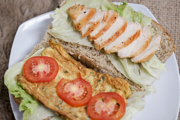 Big breakfast, bread, chicken slice, tomato, lettuce, smoked beef, egg, salad with milk. Bread sandwich fresh and healthy food meal lunch dinner breakfast slices of sandwiches.