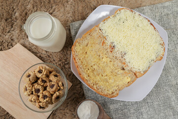 Bread with cheese, sweetened condensed milk, and butter. With white milk and snack on a table for breakfast	