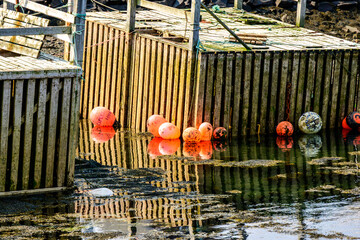 Fishing floats floating beside old wooden dock  room for text suitable as background shot in Nova Scotia Canada in summer