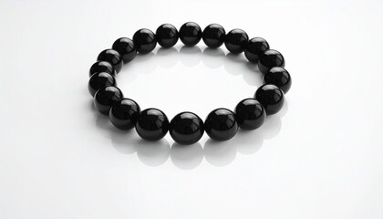 Obraz premium Black bead bracelet on white minimal background
