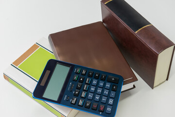電卓とビジネス書を並べた会計と計算のイメージ