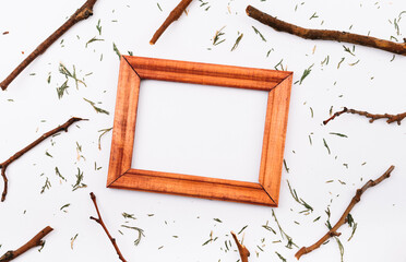 Empty wooden picture frame on white background with twigs