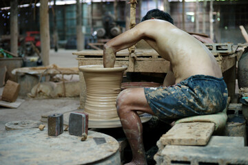 Selective focus on the clay work on the spinning tray with hands of worker