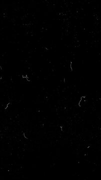 Film grain overlay with dust, scratches and noise. Vintage cinematic texture on black background for vertical video editing loop.