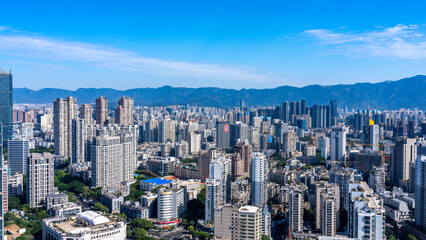 Obraz premium Urban Skyline with Modern Skyscrapers and Mountains