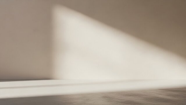 Bright natural sunlight casts a strong diagonal shadow across a minimalist empty room's warm beige wall and textured floor, creating a serene, clean, and modern interior backdrop
