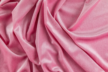 Chic velvet background of pink velvet fabric with smooth beautiful pleats. The concept of a festive background. layout for design. top view.