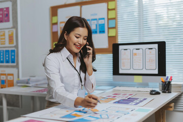 Professional woman working on UXUI design, creating wireframes and mockups for a mobile application while on a call