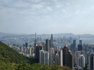Naklejka premium Panoramic view of Hong Kong skyline and Victoria Harbour from The Peak on a sunny day