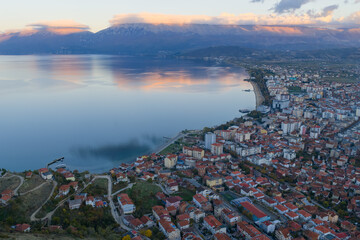 Aerial twilight view of Pogradec, Albania, with the city curving along Lake Ohrid under soft evening reflections.