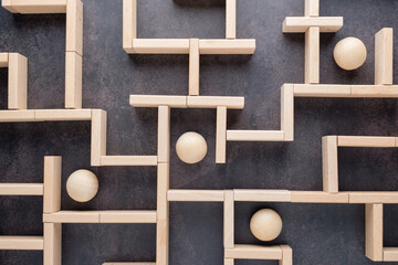 Wooden maze with multiple balls, organizations navigating complex systems, strategic planning, business challenges, people facing different choices, decisions, and direction