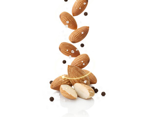 Flying almonds with milk splash isolated on black background, healthy nutrition concept showing nuts in motion, protein rich food for vegan diet and energy lifestyle
