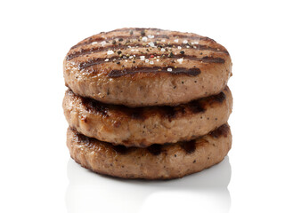 Stack of grilled burger patties isolated on black background, juicy meat cutlets with grill marks, fast food concept for barbecue cooking and protein rich meals