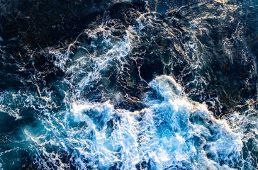 Turquoise water with reef. Powerful ocean waves. Rocky coast with sea foam. Drone shot of beauty rocky coastline. Summer beach with crashing waves. Dramatic waves on reef. Coastline from above.