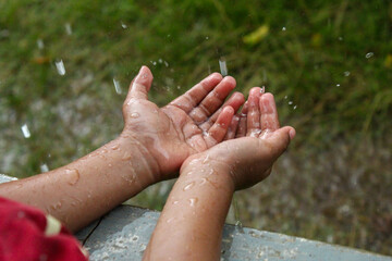 hands with splashes of falling rain
