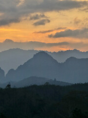 Majestic mountains of Khao Sok at sunset casting shadows over the tranquil landscape