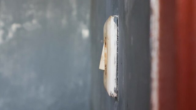Man's hand unplugging a mobile phone charger from wall socket, promoting energy conservation and electrical safety practices in residential setting. 