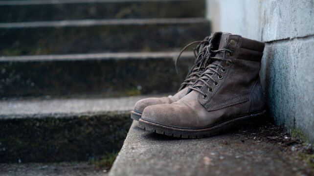 Dusty boot masonry steps urban site rugged scene with worn suede boots on concrete stair - Powered by Adobe