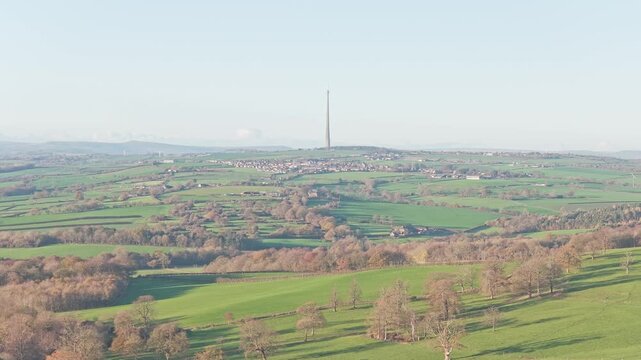 Static wide-shot of the Emley Moor Mast, symbolizing the communications link over the rolling Yorkshire region that includes the Sculpture Park and surrounding villages, England.