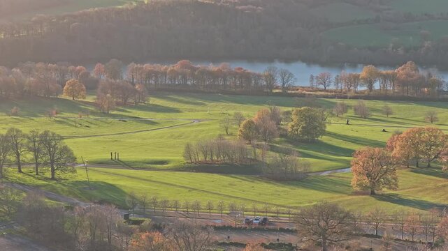 Drone ascend revealing the full extent of the picturesque parkland and the tranquil Bretton Lake in sculpted landscape of the Yorkshire Sculpture Park in West Yorkshire, UK.