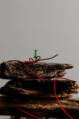 Minimal Christmas tree made from stacked firewood on neutral background. Rustic holiday concept and natural winter decor.