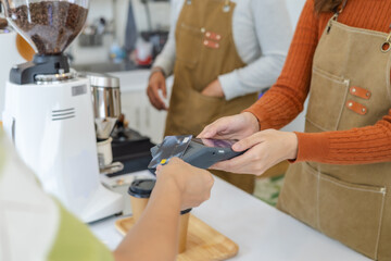 Small cafe barista couple processing credit card payment, modern technology internet banking transaction. worker handling POS terminal, secure cashless purchasing, digital lifestyle in local business