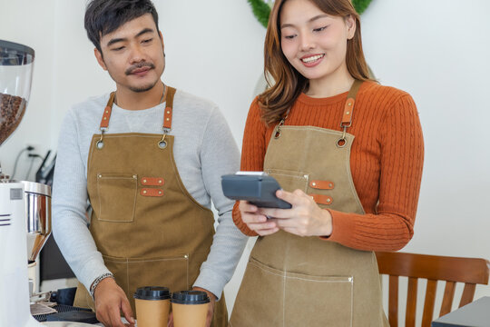 Small cafe barista couple processing credit card payment, modern technology internet banking transaction. worker handling POS terminal, secure cashless purchasing, digital lifestyle in local business - Powered by Adobe