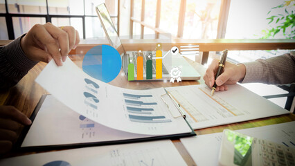 Adult Asian hands reviewing business financial reports performing data analysis strategy planning using laptop charts graphs in office meeting workspace