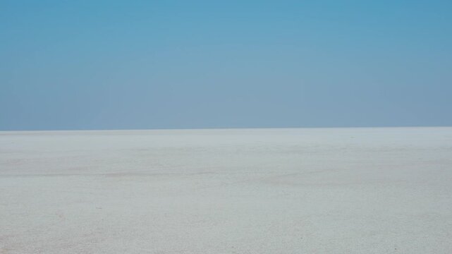 4K Landscape shot of the Rann of Kutch desert during the day with clear sky as seen during the sunny day at Kutch in Gujarat, India. Scenic desert afternoon background. White desert during day. 
