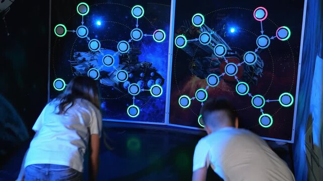 Funny children throw balls at glowing light bulbs in a modern play area. A game of marksmanship, you need to hit a glowing target of the right color. Active games for children and teenagers.