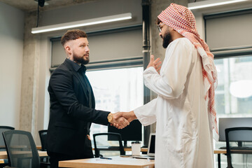 Diverse businessmen shaking hands closing business deal