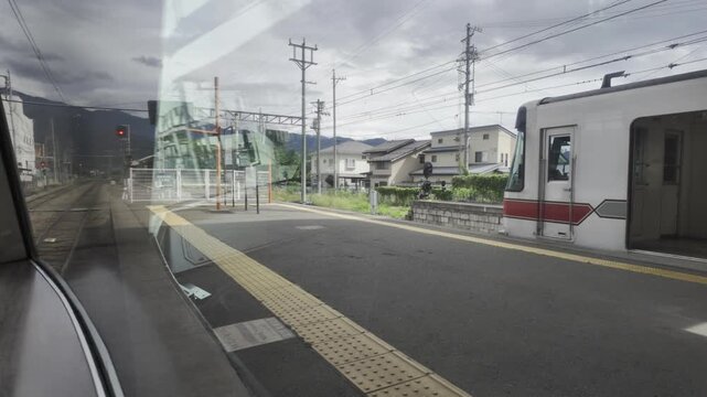 The train pulls into a station and slows to a stop, with clouds drifting slowly and traffic lights flashing rhythmically.