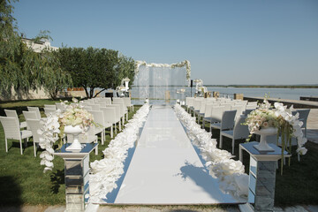 Luxury Lakeside Wedding Aisle Setup With Floral Pedestals and Arch