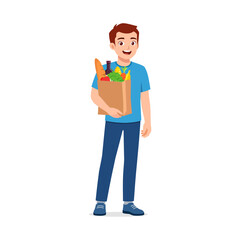 Young man smiling holding a grocery paper bag full of fresh food items after shopping happy mood