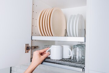 Organized Kitchen Cabinet with Plates, Cups, and Glasses Neatly Arranged on Shelves for Efficient Dining Preparation