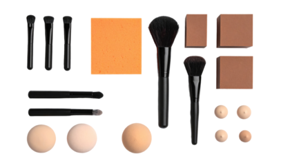 Makeup flat lay on black eyeshadow, brushes, sponges, and face powder laid out symmetrically