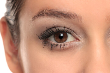 Obraz premium Close-up of a woman’s eye with mascara and eyeshadow, studio shot on a white background