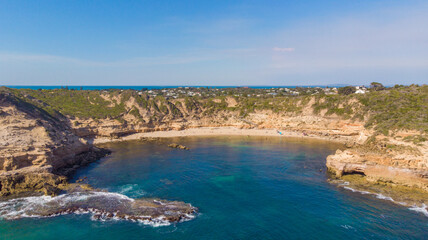 Aerial view of the dramatic cliffs embrace the tranquil turquoise waters of the bay, Cape Schanck, Victoria, Australia.